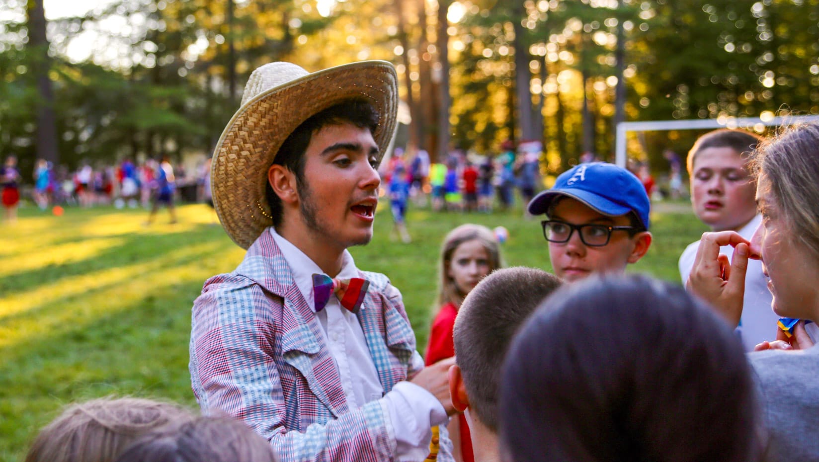 Staff talking with campers while wearing a cowboy hat