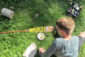 Camper painting a paddle on the Leadership Development Program