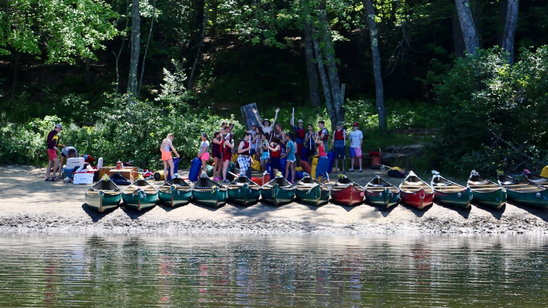 Campers standing by canoes