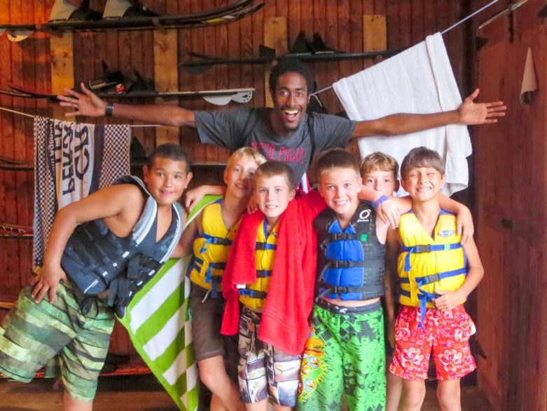 Boys wearing life jackets with staff