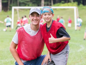 Camper and staff smiling at soccer