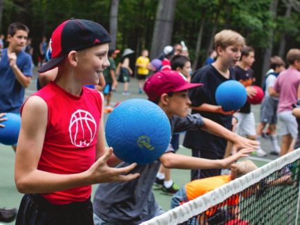 Campers throwing dodgeballs in the tennis court