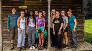 Staff and campers standing on a lodge porch