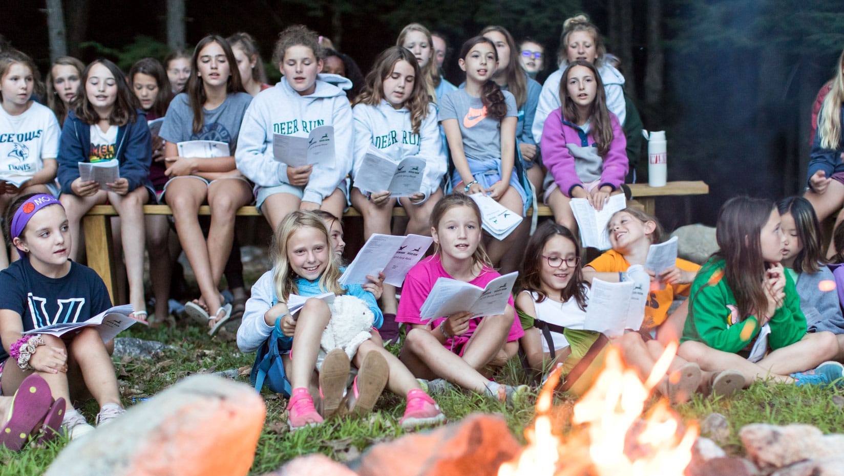 Deer Run campers singing worship songs by a campfire