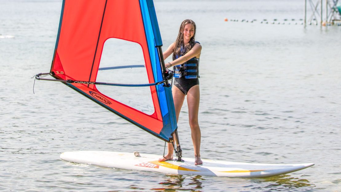 Girl windsurfing on lake