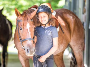 Girl standing with a horse