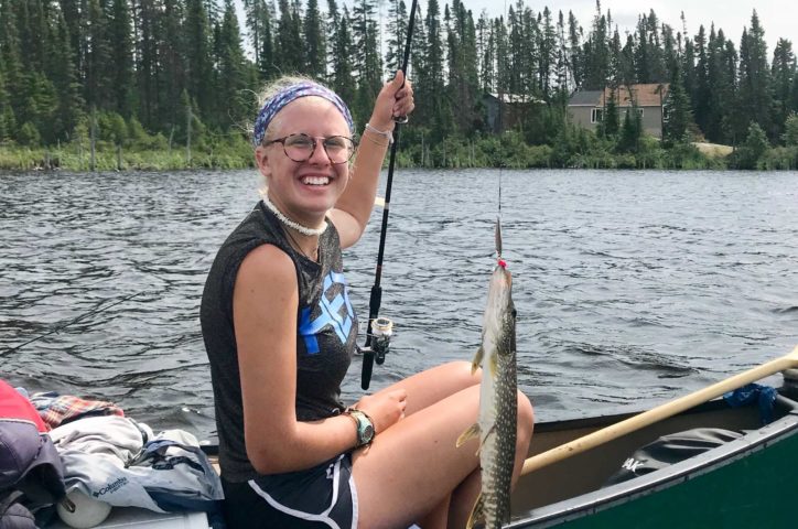 Girl catching a fish while canoeing on the Leadership Development Program