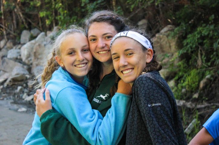 Three girls hugging on the Leadership Development Program