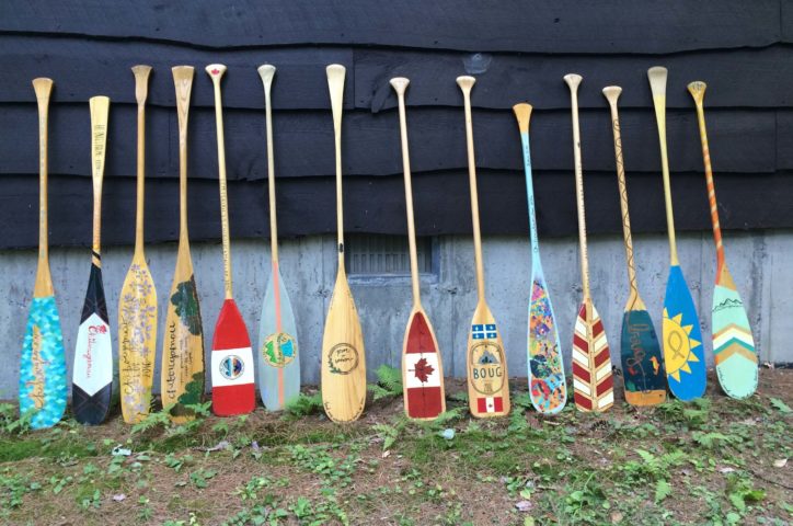 Decorated paddles leaning on a cabin on the Leadership Development Program