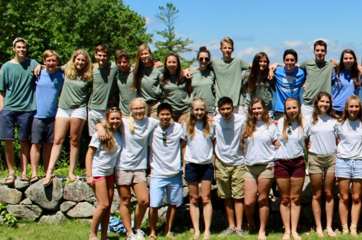 Campers on the Leadership Development Program standing by rock wall and smiling