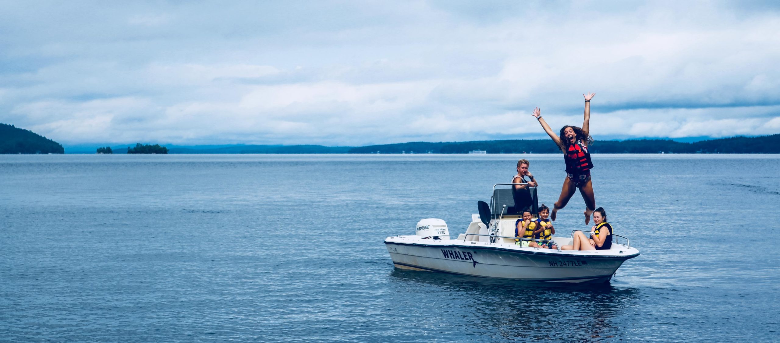 Molly jumping off the motorboat into the lake at Camp Deer Run