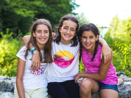 Three Deer Run campers sitting on a stone wall