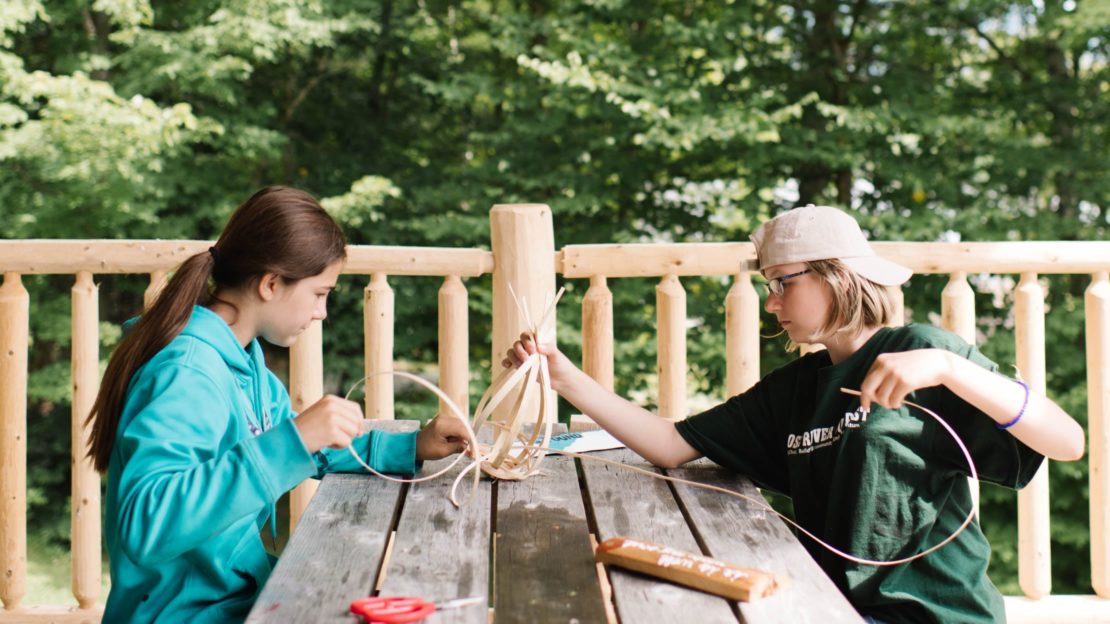 Campers weaving a basket