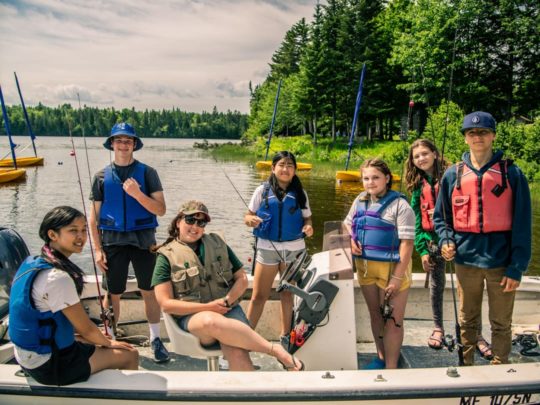 Staff and campers fishing on a boat