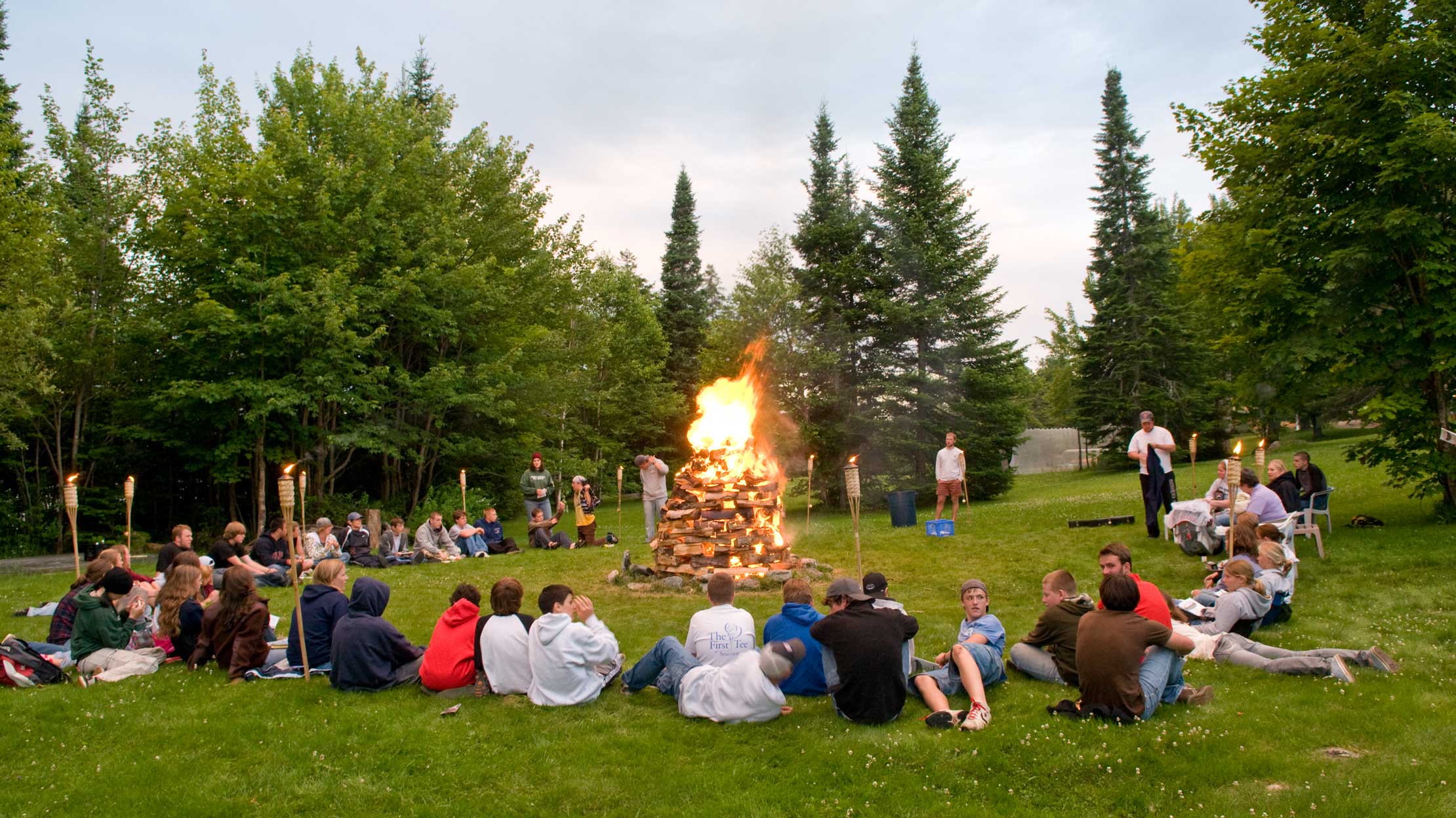 Campers and staff sitting around a campfire