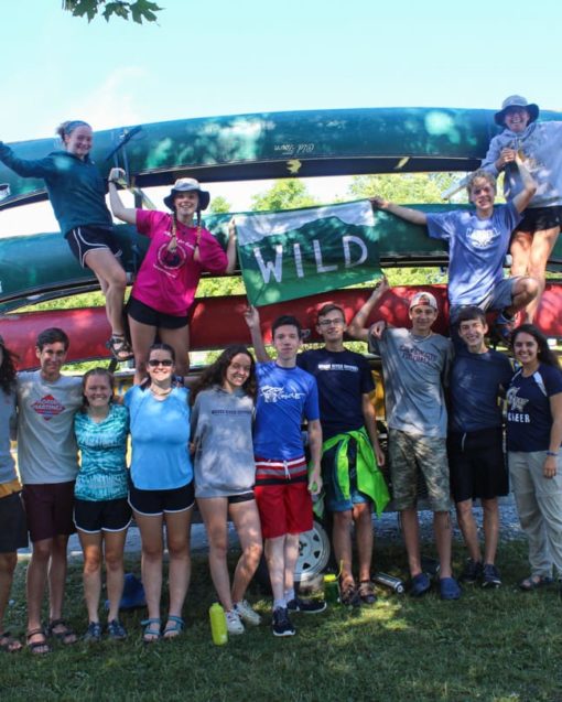 group standing by stacked canoes