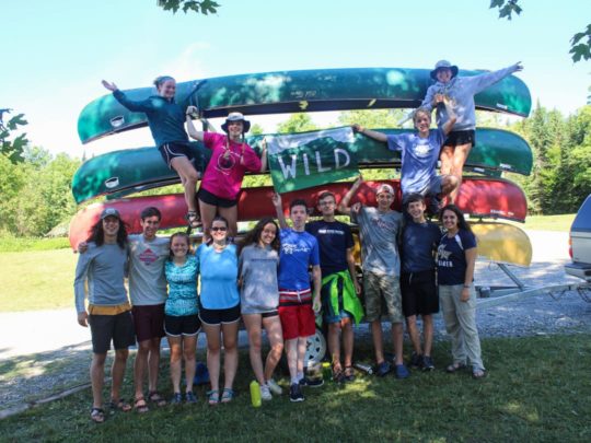 group standing by stacked canoes