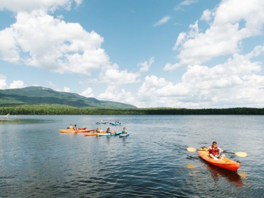 Campers and staff kayaking on a lake