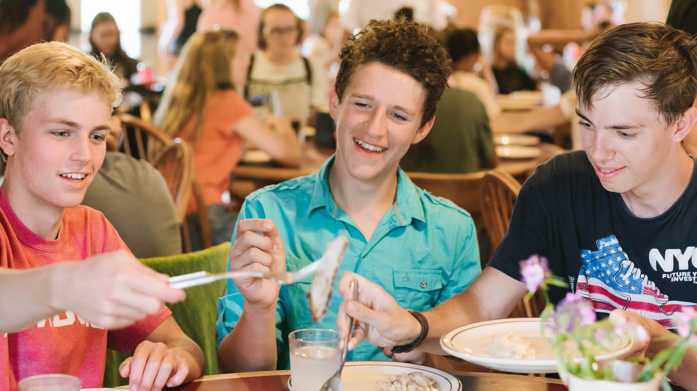 Three boys eating lunch at the dining hall