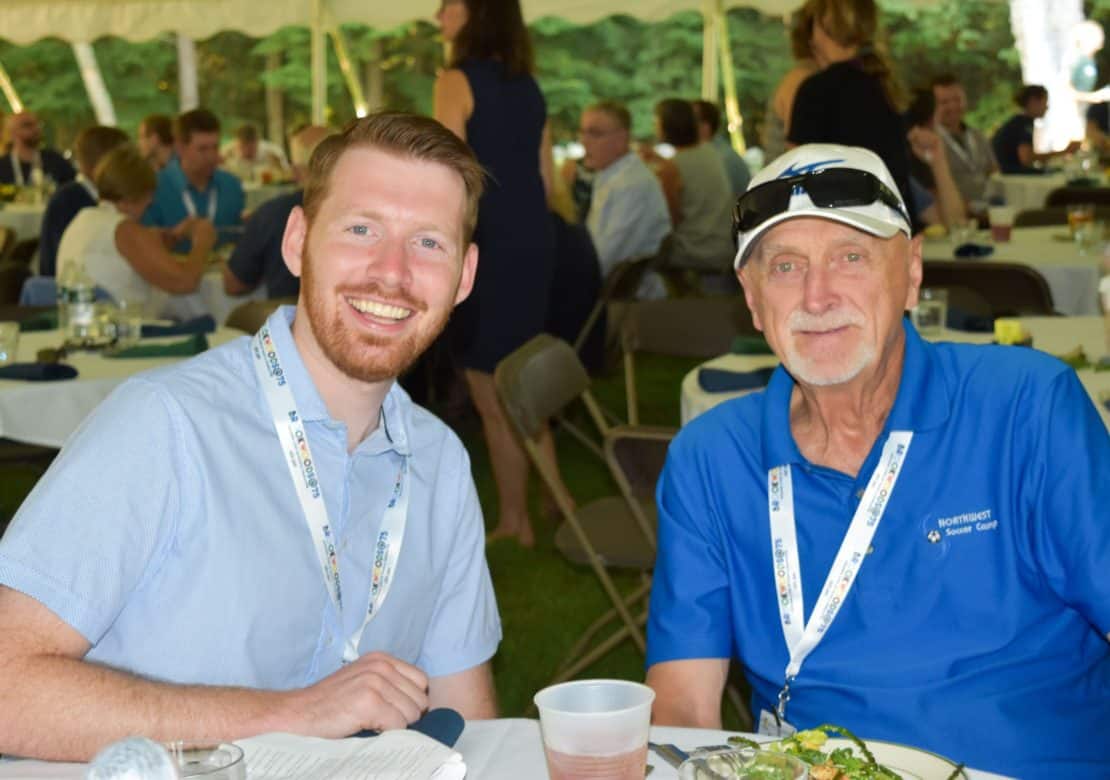 Young adult with an older man at an alumni event