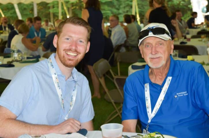 Young adult with an older man at an alumni event