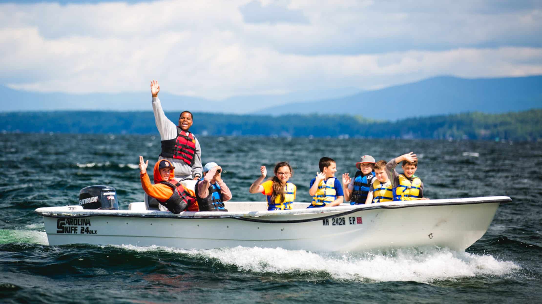 Campers on a motorboat giving a thumbs up