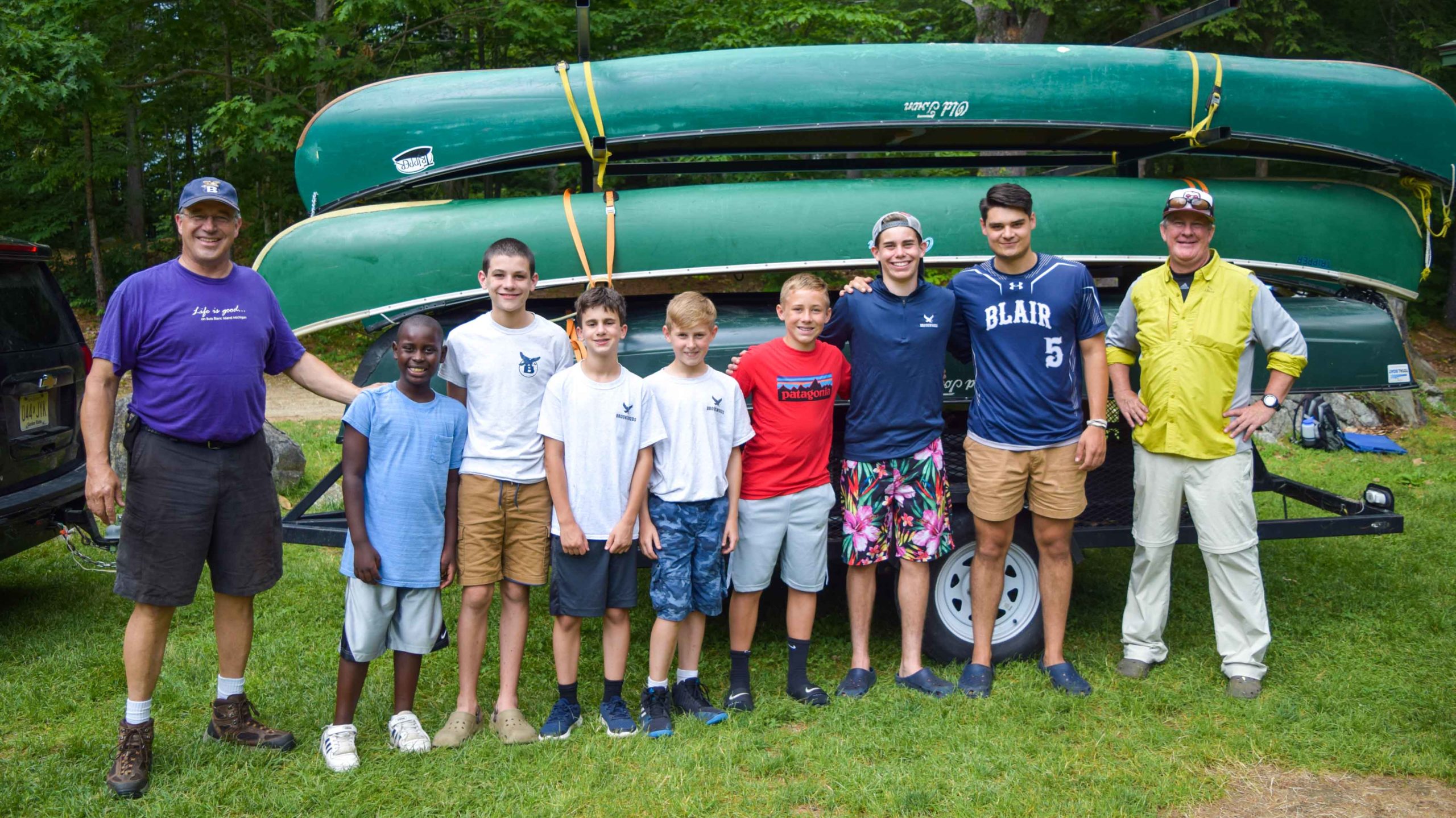 Staff and campers standing next to canoes